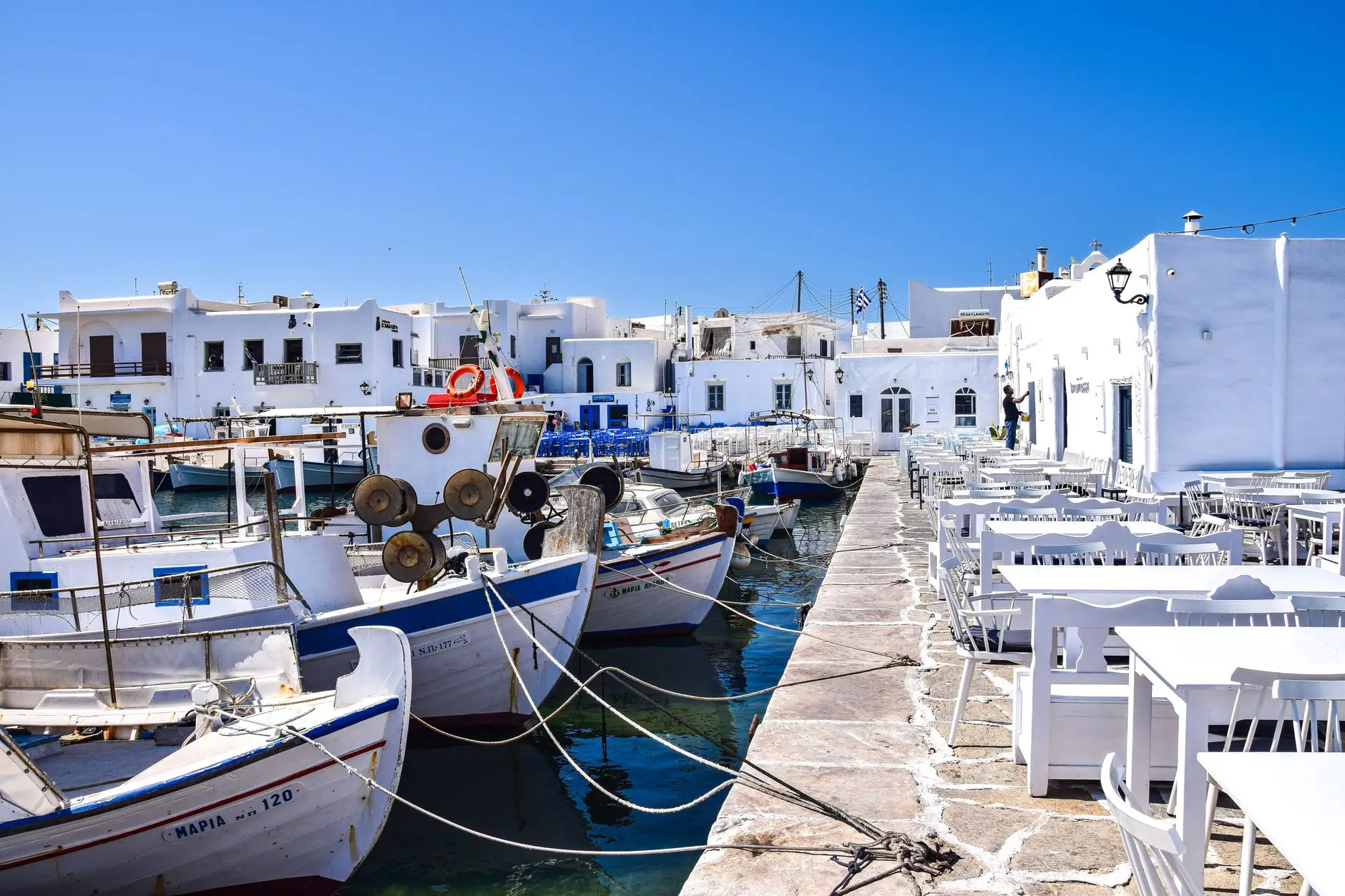 Puerto de Naoussa en Paros con barcas pesqueras y casas blancas