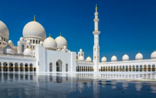 Mezquita Sheikh Zayed de Abu Dabi reflejada en el mármol Cúpulas blancas y minarete de la Gran Mezquita Sheikh Zayed de Abu Dabi reflejados en el suelo de mármol
