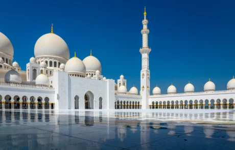 Mezquita Sheikh Zayed de Abu Dabi reflejada en el mármol Cúpulas blancas y minarete de la Gran Mezquita Sheikh Zayed de Abu Dabi reflejados en el suelo de mármol
