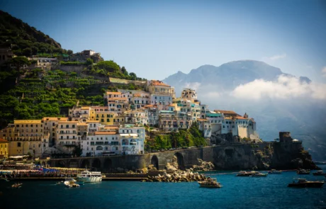 Amalfi herria terrazen eta mendien artean, itsasoaren ondoan Amalfiko etxeak mailaka portuaren gainean, mendiak lainopean, Amalfiko kostaldean