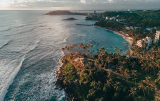Vista aérea de la bahía de Mirissa al atardecer, Sri Lanka Vista aérea de la bahía de Mirissa con palmeras y playa al atardecer en el sur de Sri Lanka
