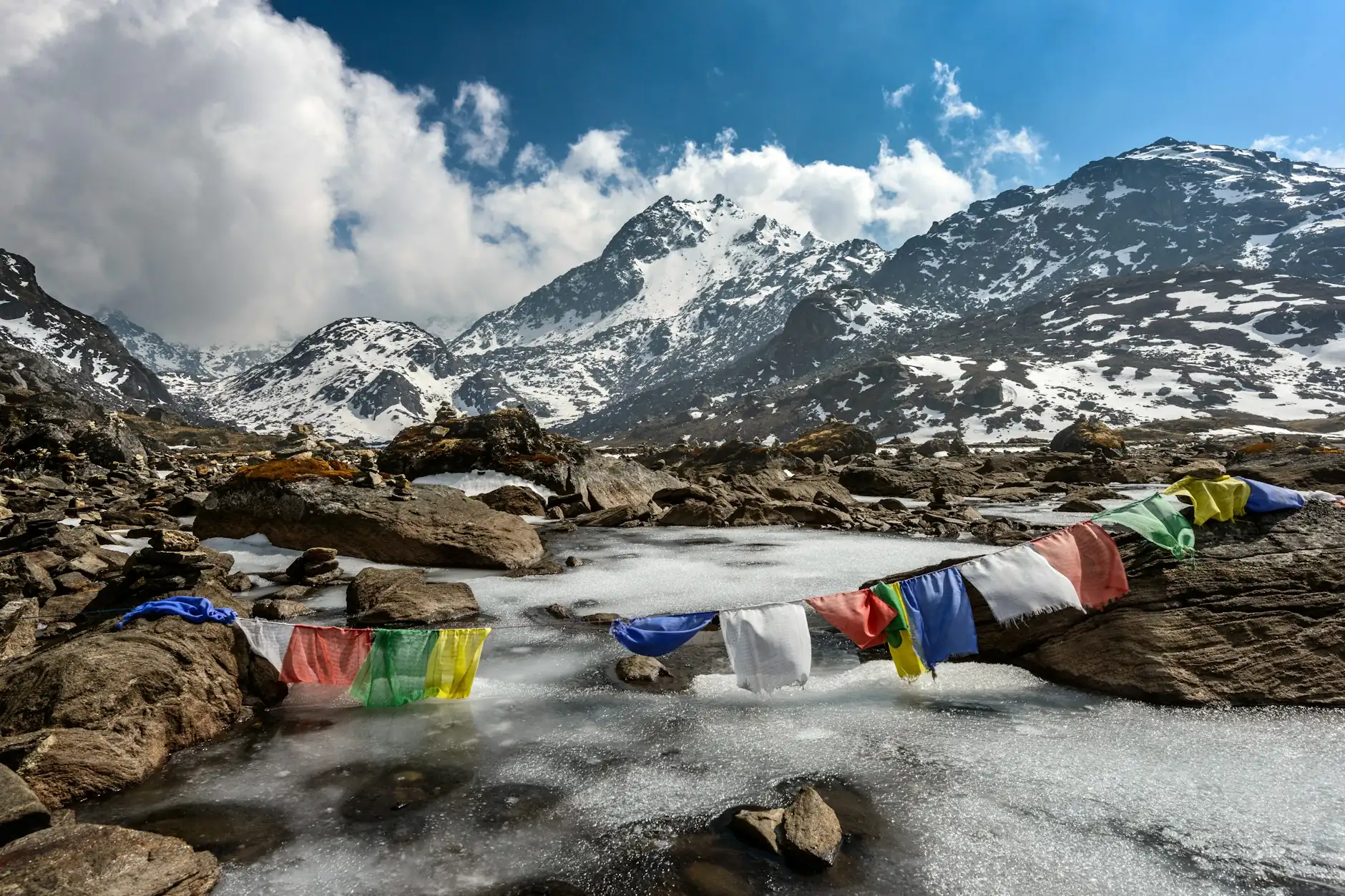 Banderas de oración ante picos nevados del Himalaya, Nepal Banderas de oración tibetanas sobre un lago helado bajo los picos nevados de Langtang, Nepal