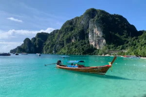 Buztan luzeko txalupa thailandiarra ur turkesen gainean, Koh Phi Phiko itsaslabarren aurrean (Thailandia)