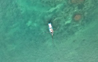 Barca tradicional de pesca en aguas turquesas de Weligama Vista cenital de una barca tradicional con balancín en las aguas turquesas de la bahía de Weligama