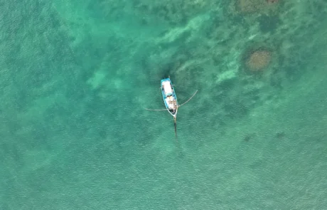 Barca tradicional de pesca en aguas turquesas de Weligama Vista cenital de una barca tradicional con balancín en las aguas turquesas de la bahía de Weligama