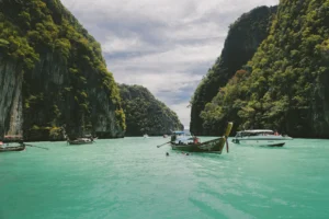 Barcas tradicionales de cola larga flotando entre acantilados verdes en las islas Phi Phi, Tailandia