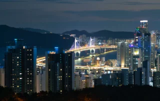 Rascacielos de Busan y el puente Gwangan iluminados de noche Skyline nocturno de Busan con rascacielos iluminados y el puente Gwangan sobre la bahía al fondo