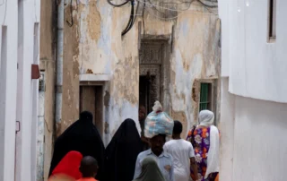 Bizilagunak Stone Towngo kalexka estu batean oinez, fatxada zaharren artean, Zanzibar