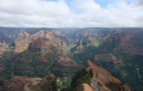 Waimea arroilaren horma gorrixka eta berdeak hodei zuriko zeru baten azpian, Kauain, Hawaiin