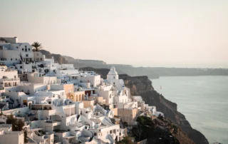 Pueblo de casas blancas de Santorini en lo alto del acantilado sobre la caldera, con luz suave