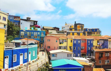 Kolore biziko etxe mailakatuak Valparaisoko muinoetan, zeru urdinaren azpian