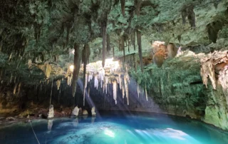 Ur turkesako zenotea estalaktitekin Riviera Mayan Lurpeko zenotea, ur turkesa, estalaktitak eta argi-izpiak dituena, Riviera Mayan