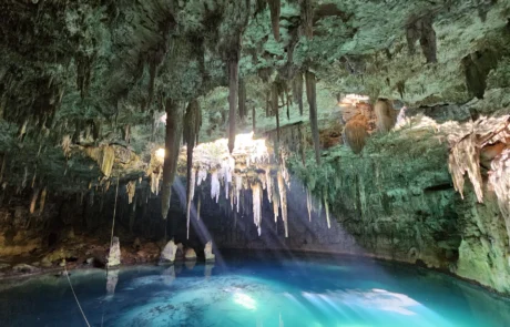 Ur turkesako zenotea estalaktitekin Riviera Mayan Lurpeko zenotea, ur turkesa, estalaktitak eta argi-izpiak dituena, Riviera Mayan