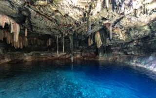 Ur urdin gardeneko lurpeko zenotea Yucatánen Kobazulo bateko zenotea, estalaktitekin eta ur urdin gardenekin, Yucatán penintsulan