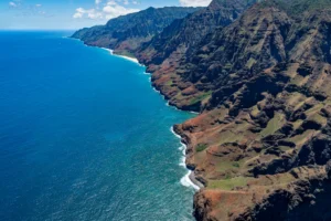 Vista aérea de los acantilados verdes de la costa de Na Pali sobre el océano turquesa en Kauai, Hawái