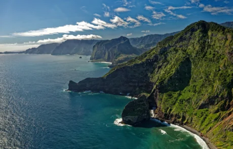 Costa norte de Madeira con acantilados verdes sobre el océano Acantilados verdes de la costa norte de Madeira cayendo sobre el océano Atlántico en un día soleado