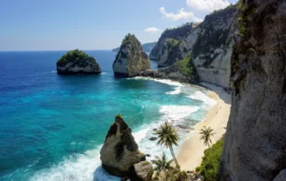 Diamond Beach en Nusa Penida, Bali, con aguas turquesas Aguas turquesas, arena blanca y rocas de Diamond Beach en Nusa Penida, Bali, entre acantilados