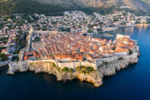 Vista aérea del casco antiguo amurallado de Dubrovnik sobre el Adriático con luz dorada
