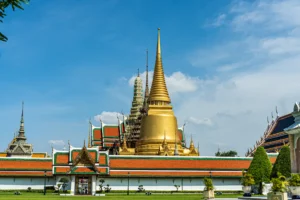 Estupa dorada y tejados rojos y verdes del Gran Palacio de Bangkok en un día soleado