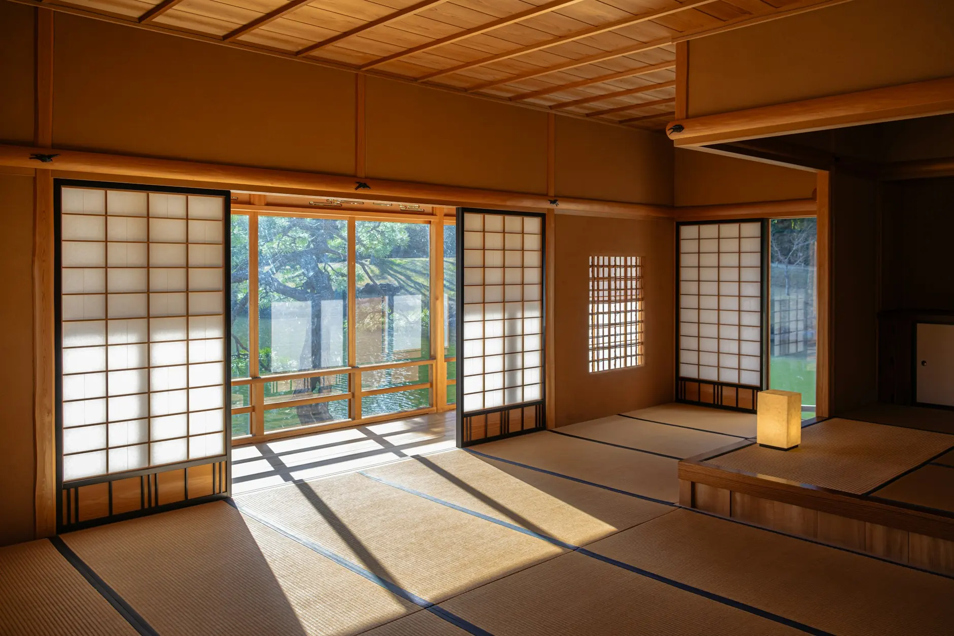 Habitación tradicional de ryokan con suelo de tatami y puertas shoji abiertas al jardín, Japón