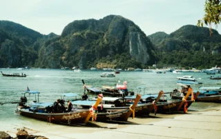 Isats luzeko txalupa tradizionalak Phi Phiko ur turkesen eta labarren ertzean, Krabi