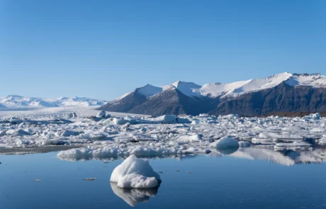 Icebergs flotando en la laguna glaciar de Jökulsárlón, Islandia Icebergs flotando en las aguas azules de la laguna glaciar de Jökulsárlón con montañas nevadas al fondo