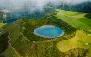 Aintzira bolkaniko turkesa krater berde batean, São Miguel Krater baten barruko aintzira turkesa airetik, larre berdez inguratuta, São Miguelen, Azoreak