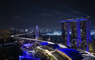 Marina Bay Sands y la noria de Singapur iluminados de noche Vista nocturna de Marina Bay en Singapur con el hotel Marina Bay Sands y la noria iluminados