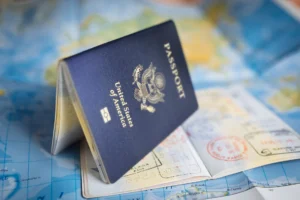 Pasaporte entreabierto con sellos de viaje apoyado sobre un mapa del mundo de colores al preparar el viaje