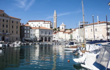 Pirango portua Done Jurgiren kanpandorrearekin, Eslovenia Itsasontziak Pirango portu txikian, fatxada veneziarrak eta Done Jurgiren kanpandorrea atzealdean