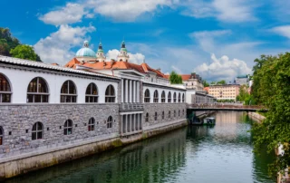 Ljubljanica ibaia eta Plečniken merkatua katedralaren ondoan, Ljubljana Plečniken merkatuko zutabeak Ljubljanica ibaiaren ondoan, Ljubljanako katedralaren kupularekin