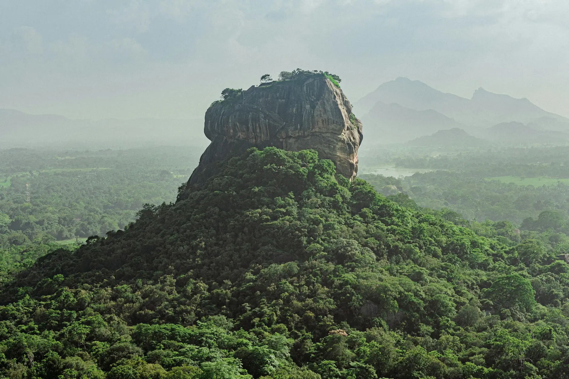Roca del León de Sigiriya sobre la selva de Sri Lanka La Roca del León de Sigiriya alzándose sobre la selva verde y las montañas de Sri Lanka