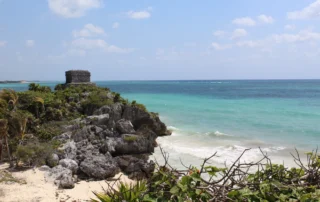Templo maya de Tulum sobre un acantilado junto a una playa de aguas turquesas en Riviera Maya