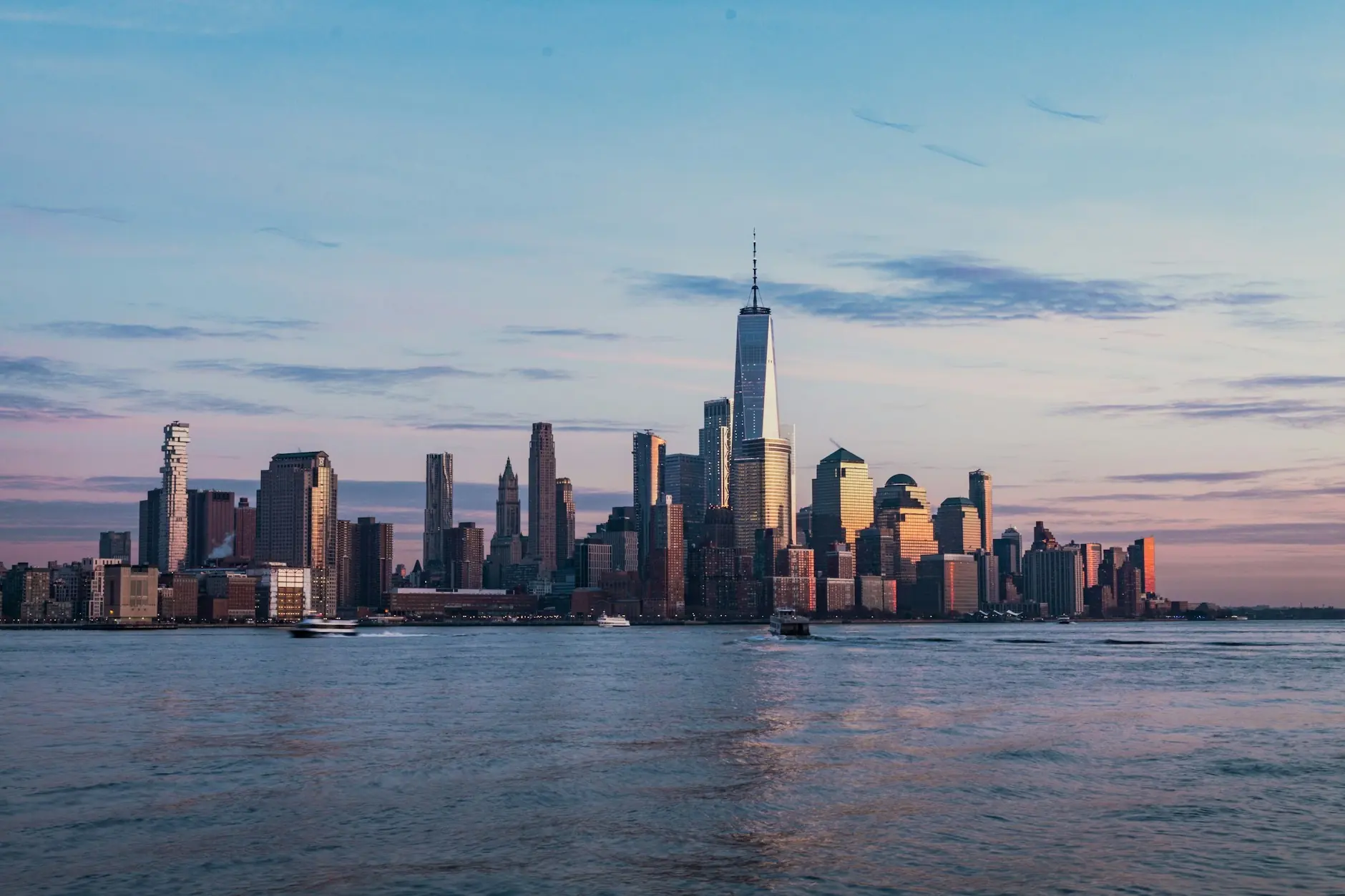 New Yorkeko Manhattan beheko etxe orratzak Hudson ibaian islatuta, ilunabarrean