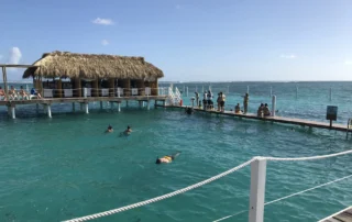 Snorkela palapa duen kai baten ondoan Punta Canan Bainulariak snorkelean ur turkesetan, palapa duen kai baten ondoan, Punta Canan