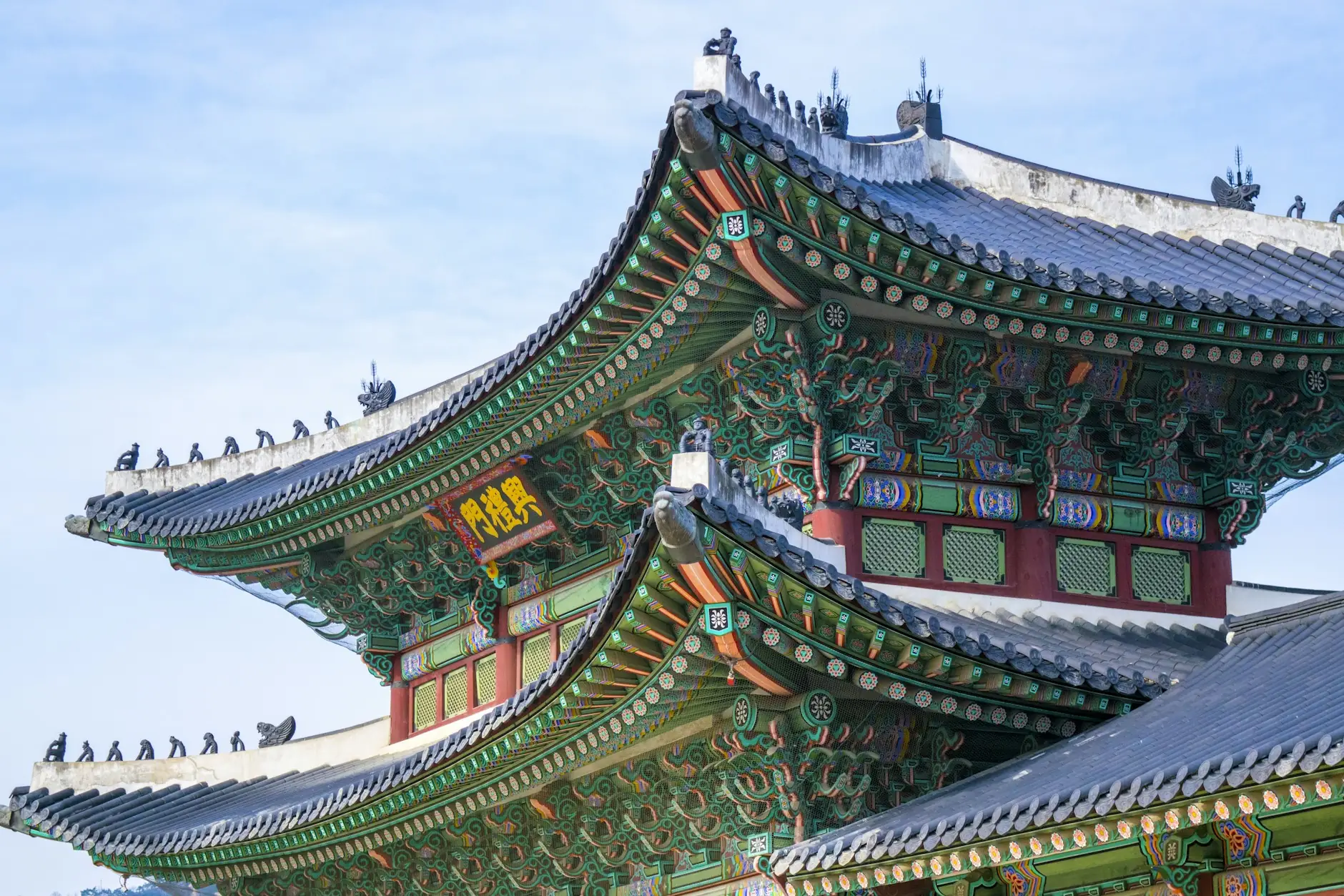 Seulgo Gyeongbokgung jauregiko teilatu-hegal berde eta gorriak zeru urdinaren kontra