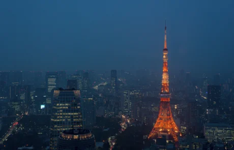 Torre de Tokio iluminada sobre el skyline nocturno Torre de Tokio iluminada en naranja sobre los rascacielos de la ciudad de noche
