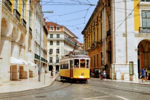 Tranvía amarillo de Lisboa recorriendo una calle de fachadas históricas en un día soleado
