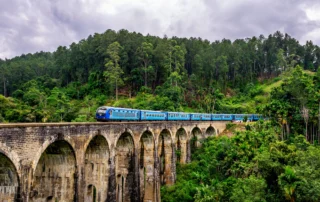 Tren azul cruzando el puente de los Nueve Arcos en Ella Tren azul cruzando el puente de los Nueve Arcos entre la selva de Ella, Sri Lanka