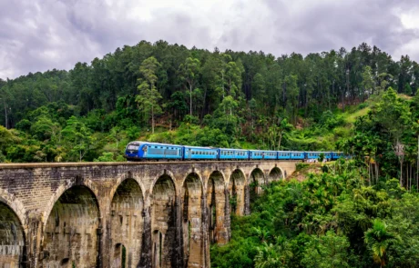 Tren azul cruzando el puente de los Nueve Arcos en Ella Tren azul cruzando el puente de los Nueve Arcos entre la selva de Ella, Sri Lanka