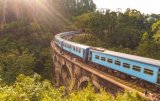 Tren urdina harrizko biaduktu batean bihurgunea hartzen, oihanez inguratuta, Ellatik gertu, Sri Lankan