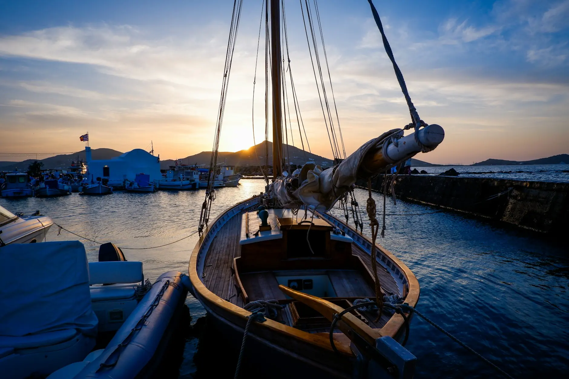 Velero de madera amarrado en el puerto de Naoussa, en Paros, con el cielo del atardecer