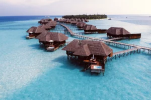 Villas sobre el agua unidas por pasarelas de madera en una laguna turquesa de Maldivas