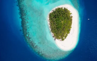 Harea zuri eta arrezife turkesa dituen uharte txiki baten airetiko ikuspegia, Maldivetako Baa atoloian