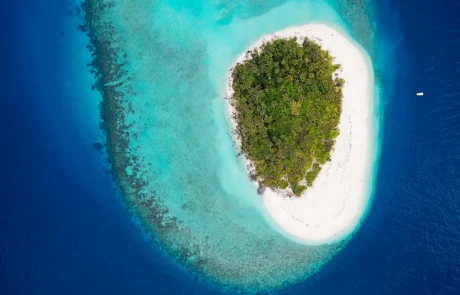 Harea zuri eta arrezife turkesa dituen uharte txiki baten airetiko ikuspegia, Maldivetako Baa atoloian