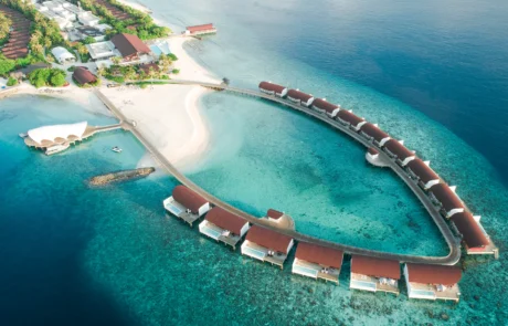 Maldivetako resort baten airetiko ikuspegia, ur gaineko villek arku bat osatzen dutela aintzira turkesean