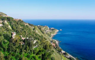 Costa jónica vista desde las colinas de Taormina, Sicilia Laderas verdes de Taormina que bajan hasta el mar Jónico azul intenso en Sicilia